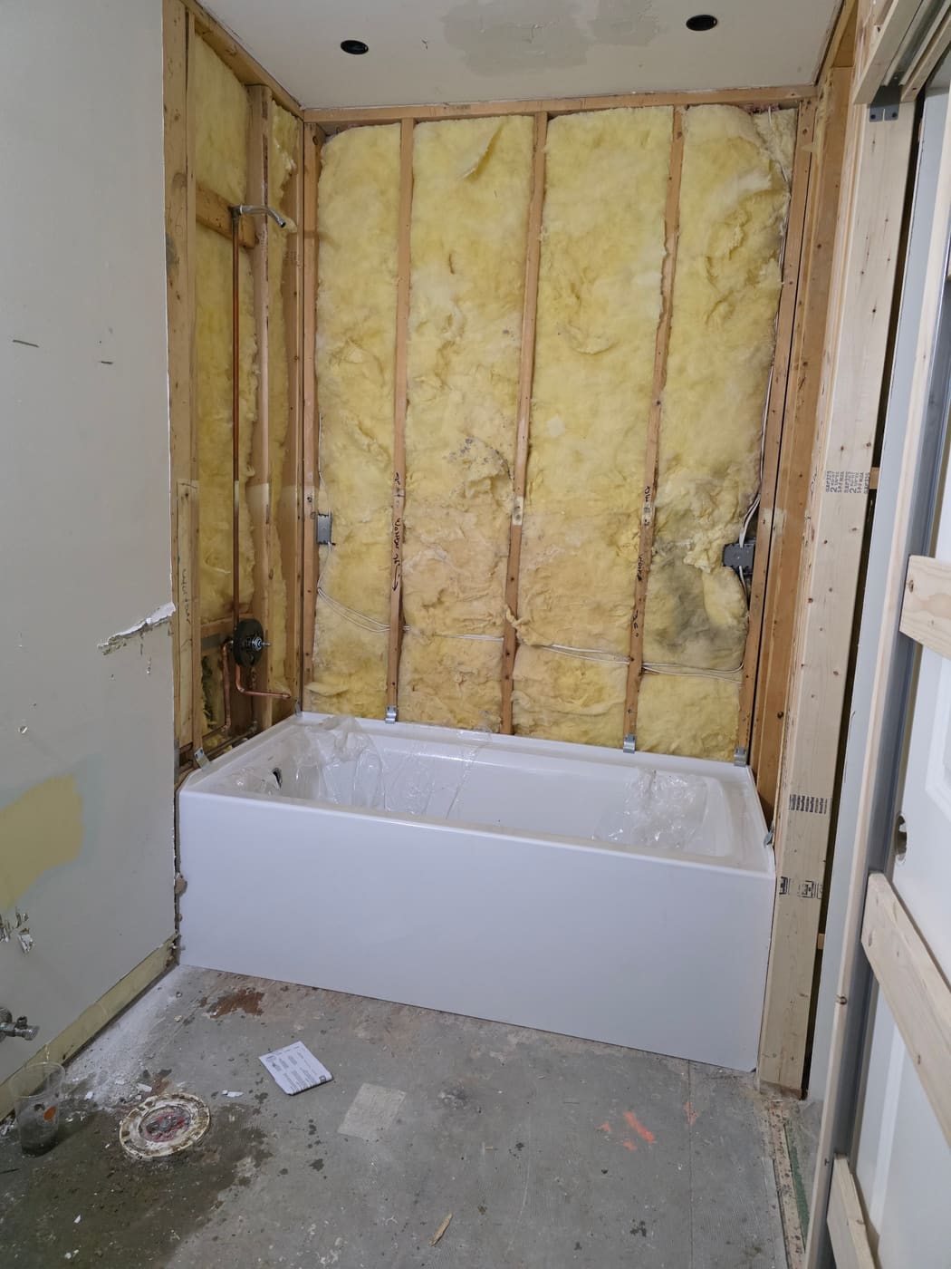 Alcove tub set in place during a bathroom remodel rough-in
